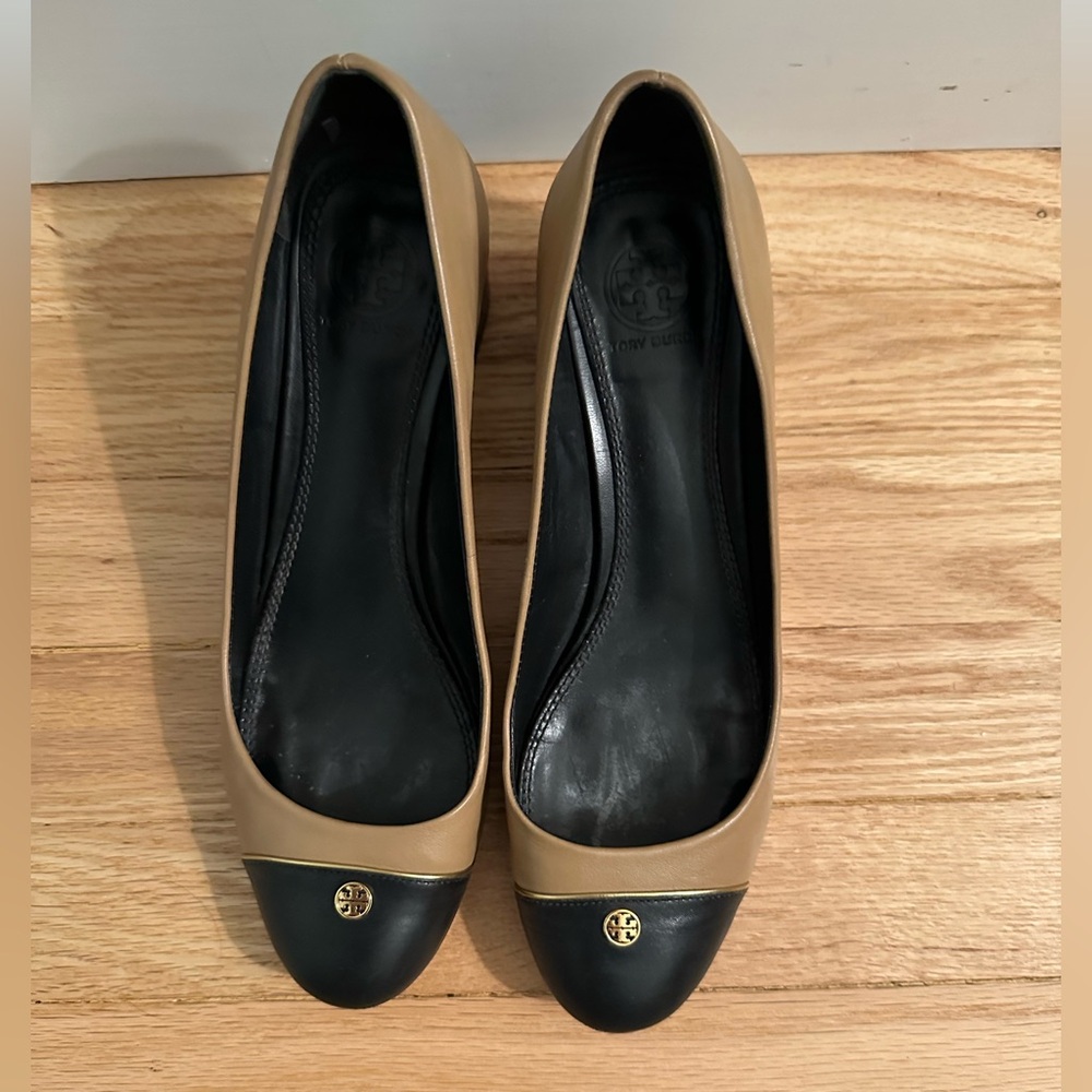 Tory Burch Tan and Black mid heel stacked pumps. Gold TB logo on front.